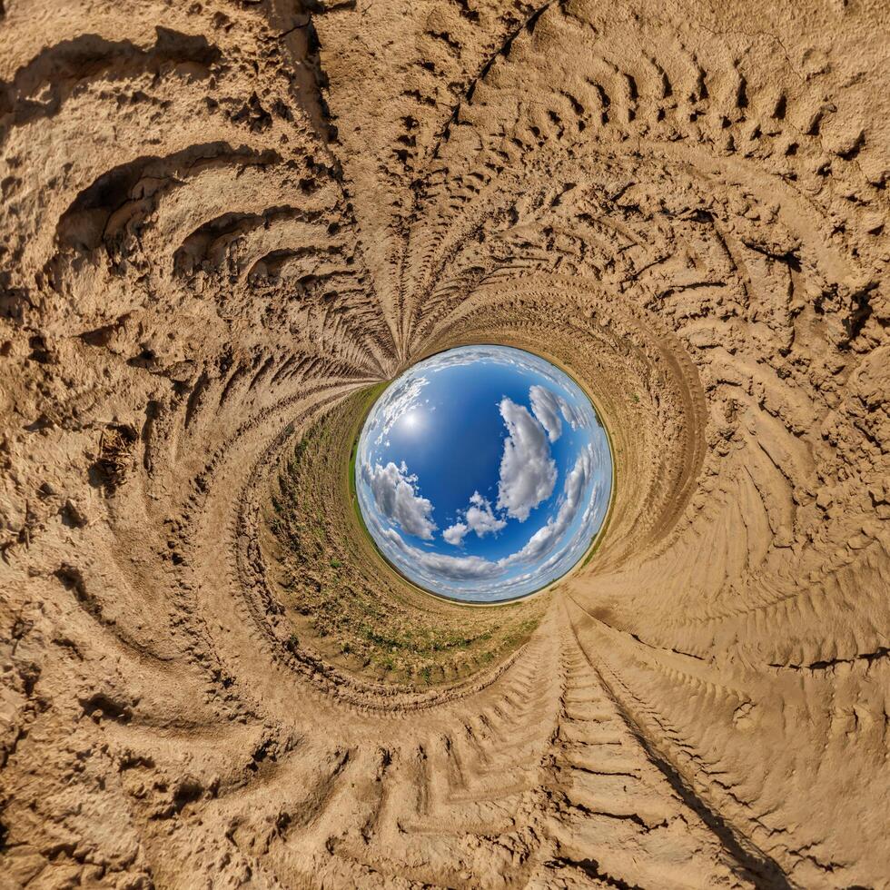 blue hole sphere or globe little planet inside sand or dry ground frame background with tractor tracks photo