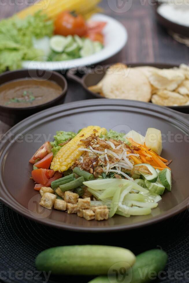 Close up of gado-gado ingredients in a plate, various vegetables and fried tempeh photo