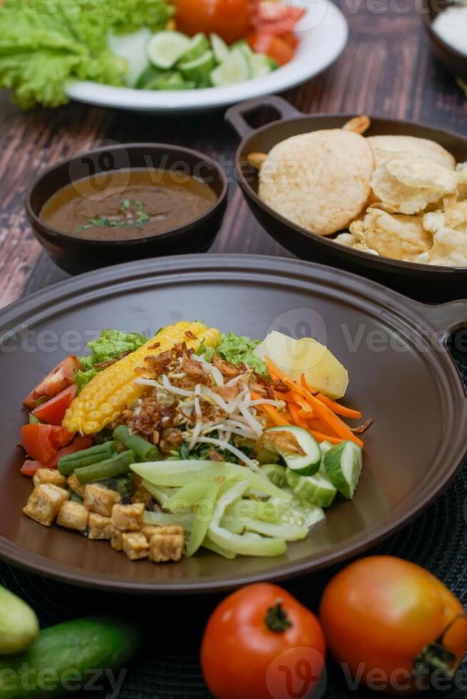 Close up of gado-gado ingredients in a plate, various vegetables and fried tempeh photo
