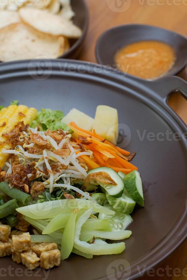 Close up of gado-gado ingredients in a plate, various vegetables and fried tempeh photo