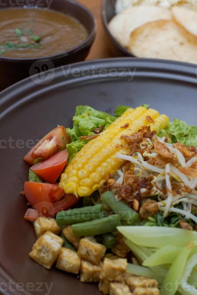 Close up of gado-gado ingredients in a plate, various vegetables and fried tempeh photo