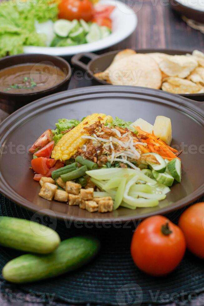 Close up of gado-gado ingredients in a plate, various vegetables and fried tempeh photo