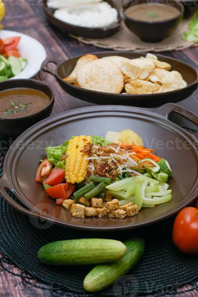 Close up of gado-gado ingredients in a plate, various vegetables and fried tempeh photo