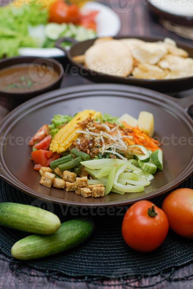 Close up of gado-gado ingredients in a plate, various vegetables and fried tempeh photo