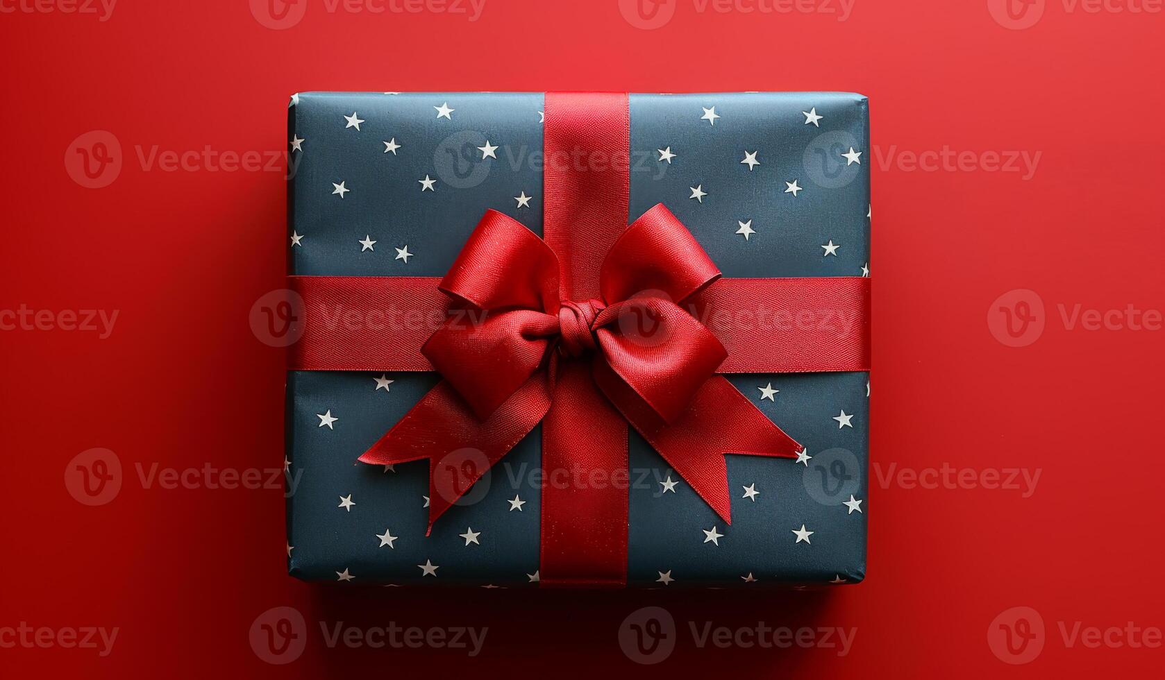 Decoratively Wrapped Gift Box With Red Ribbon on Red Background photo