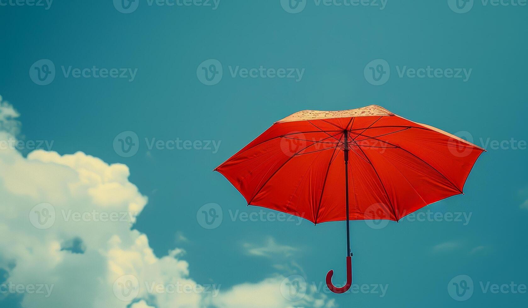 Bright Red Umbrella Floating in Clear Blue Sky With Clouds photo