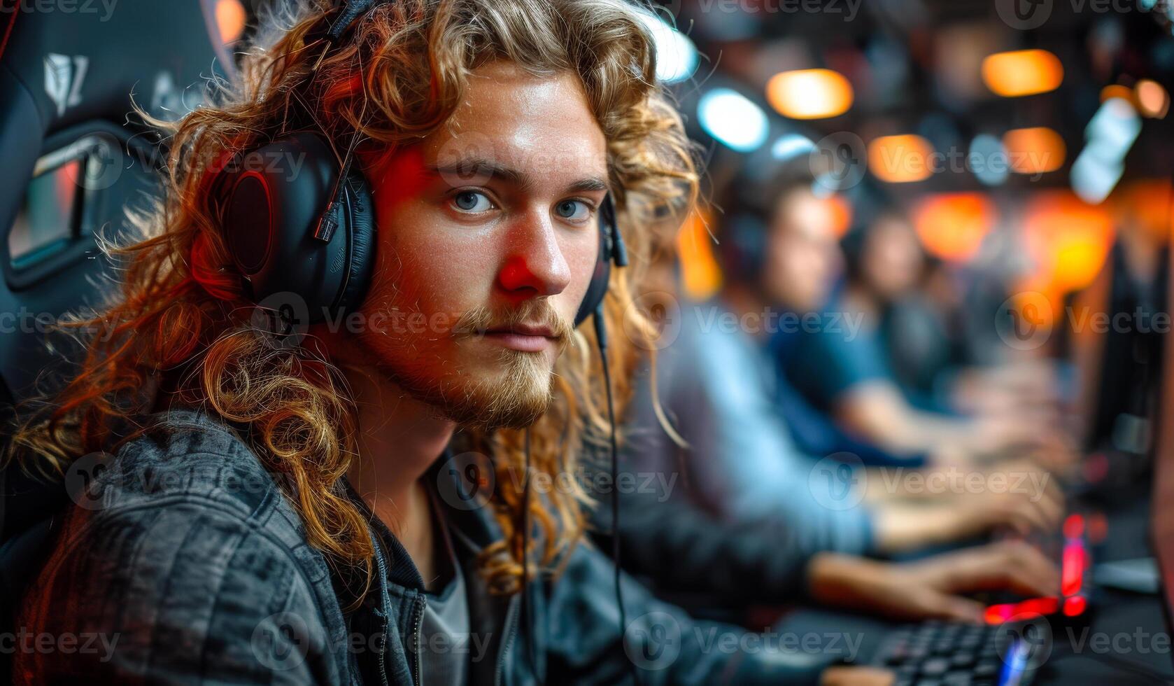 A man with long hair is wearing headphones and looking at the camera photo
