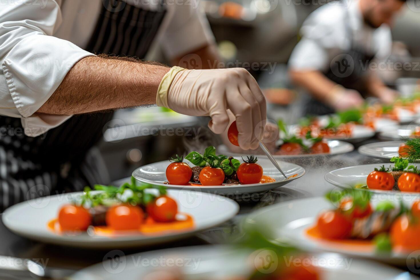 A skilled chef is carefully adding fresh tomatoes to a plate of food photo