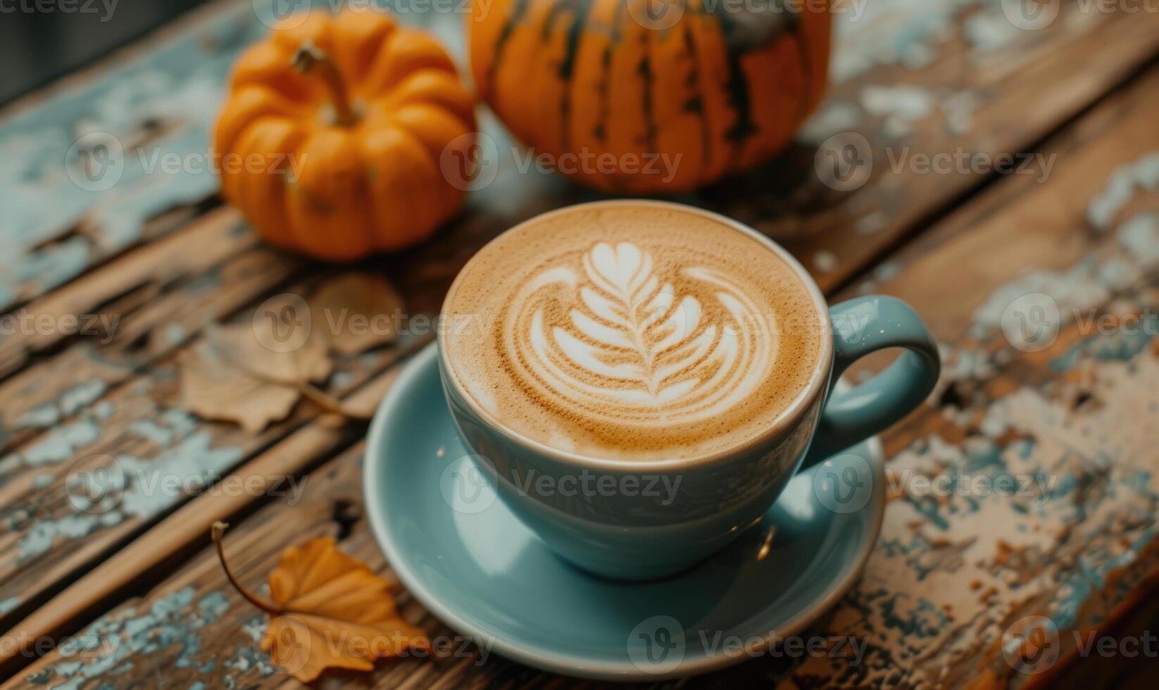 A latte art coffee with pumpkin slices and a pumpkin in the background photo