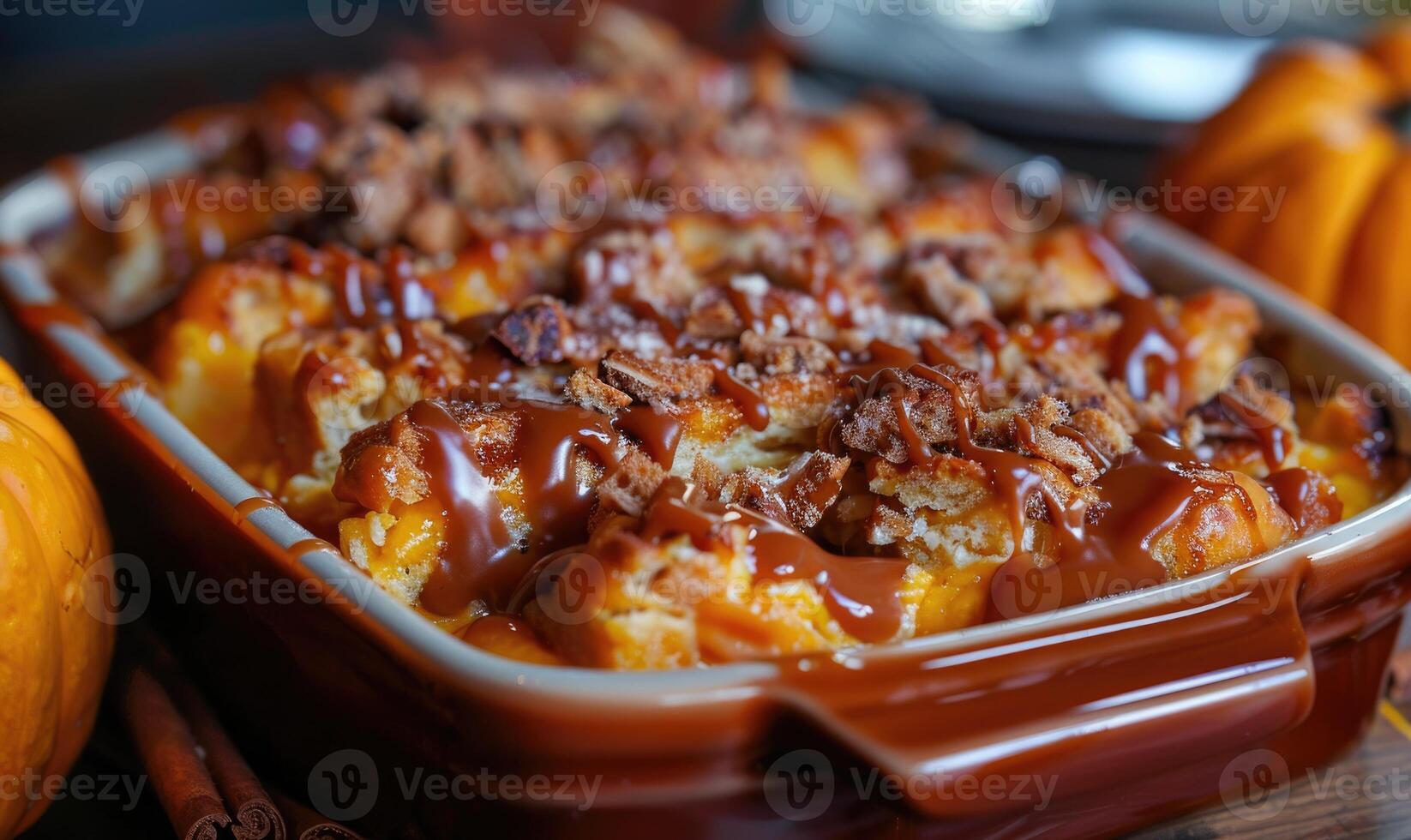 A pumpkin bread pudding with a caramel drizzle served in a baking dish photo