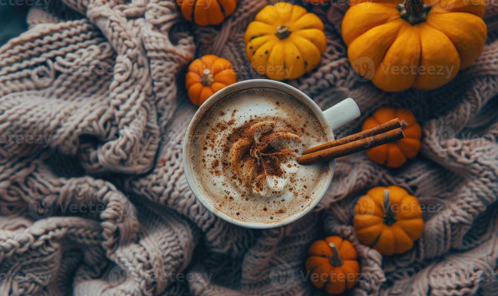 A pumpkin spice latte with a cinnamon stick photo