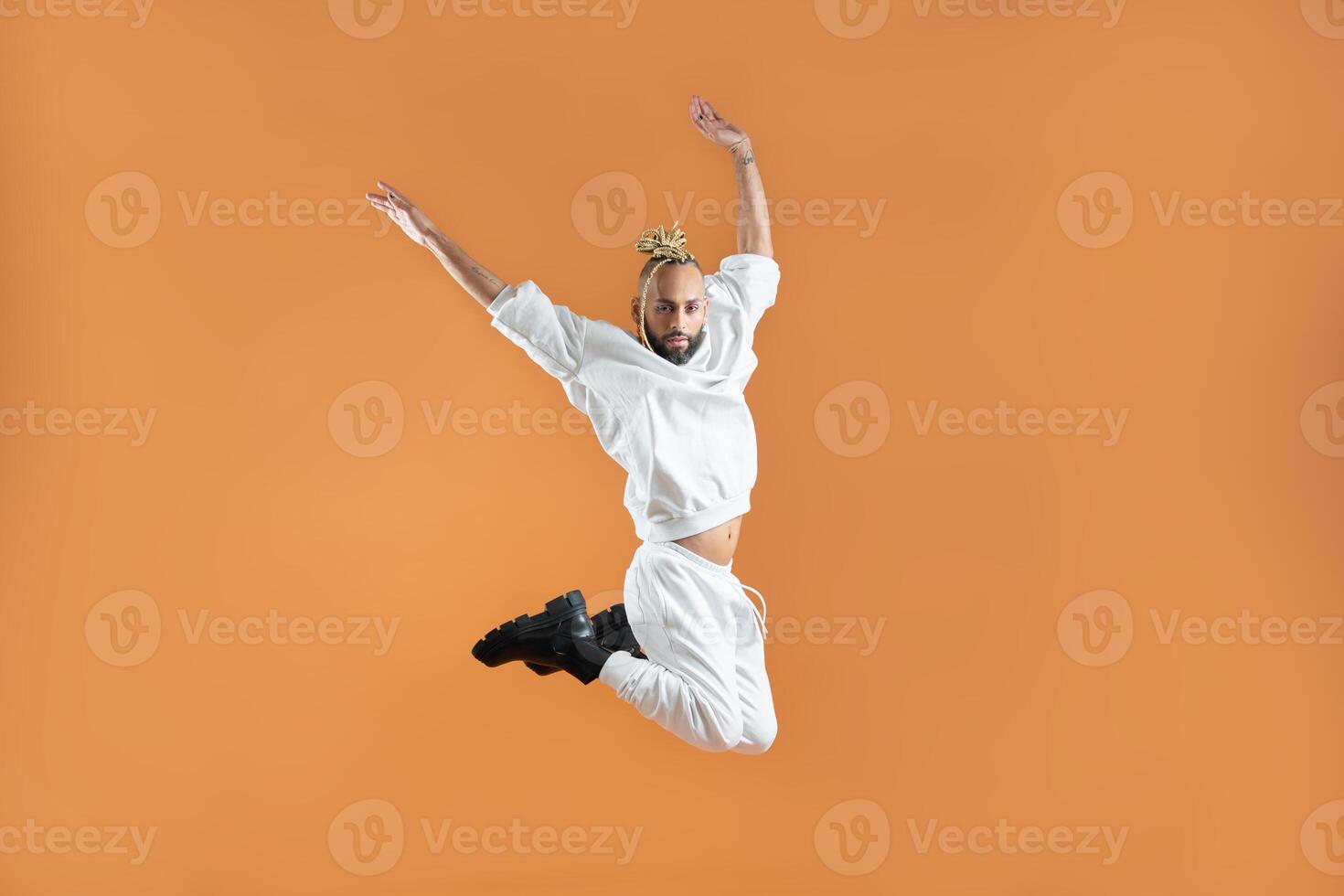 Gay man dancing isolated on orange photo