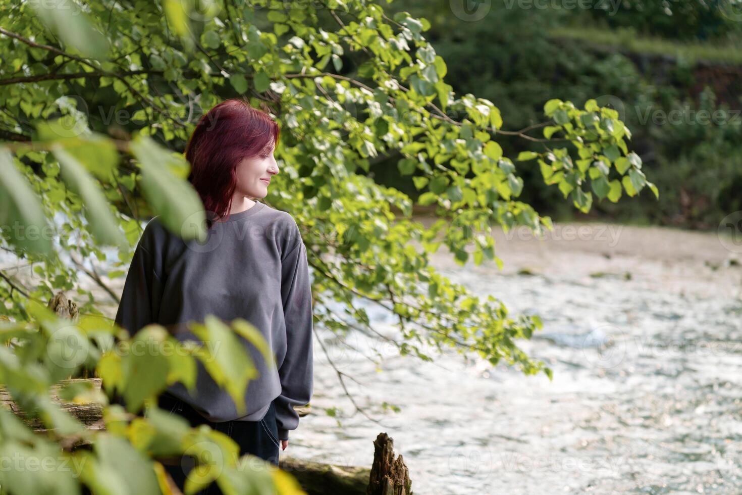millennial zoomer surrounded by the tranquil beauty of nature, her bold personal aesthetic complemented by the scenic riverside setting photo