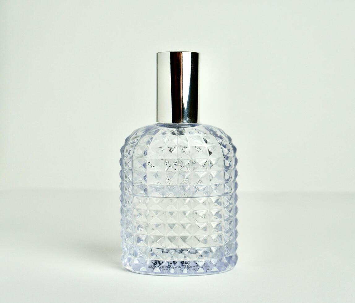 Unisex textured glass perfume bottle container with lid on isolated on horizontal white background. photo