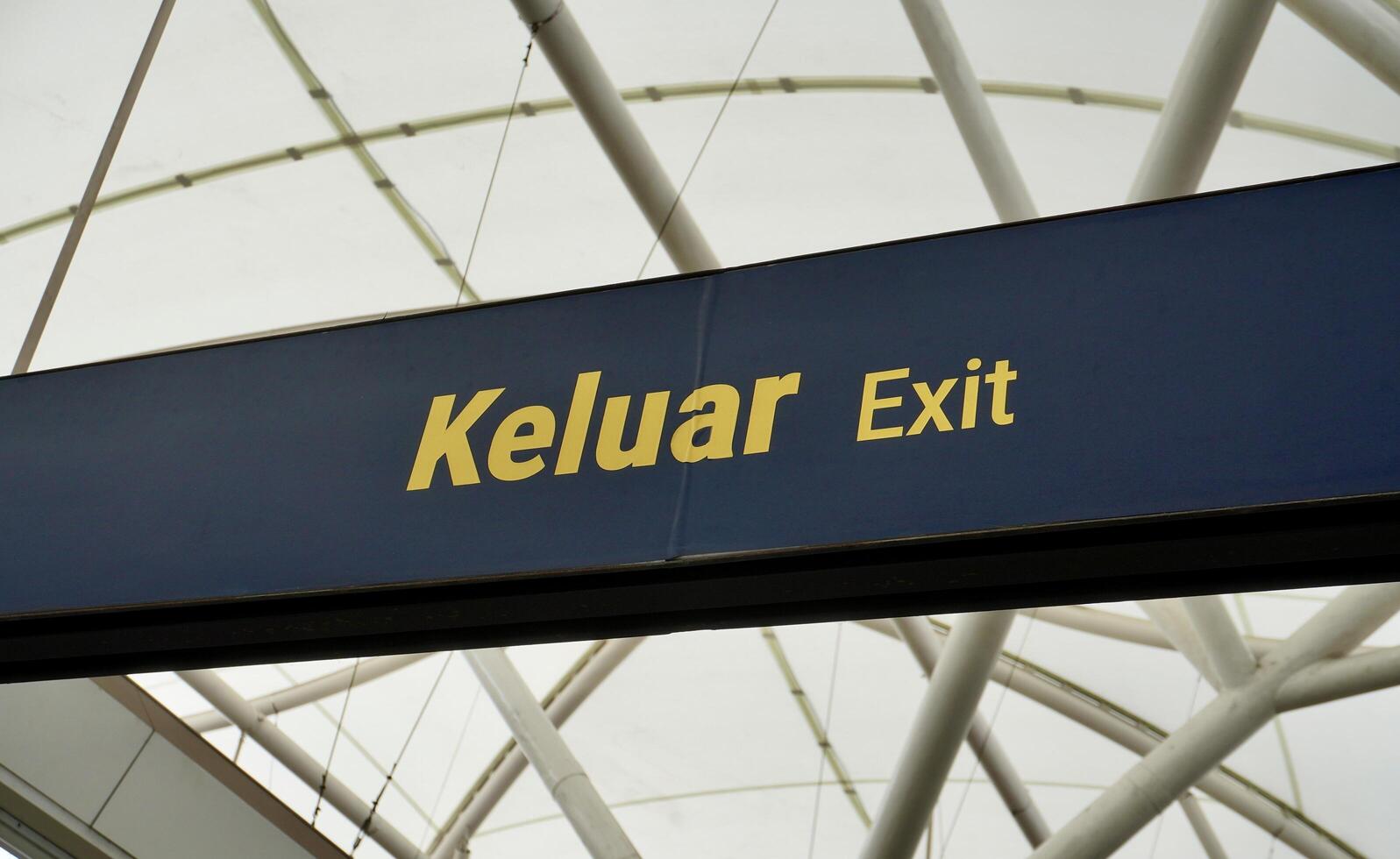 Exit sign board in horizontal train station indoor ceiling structure environment background. photo