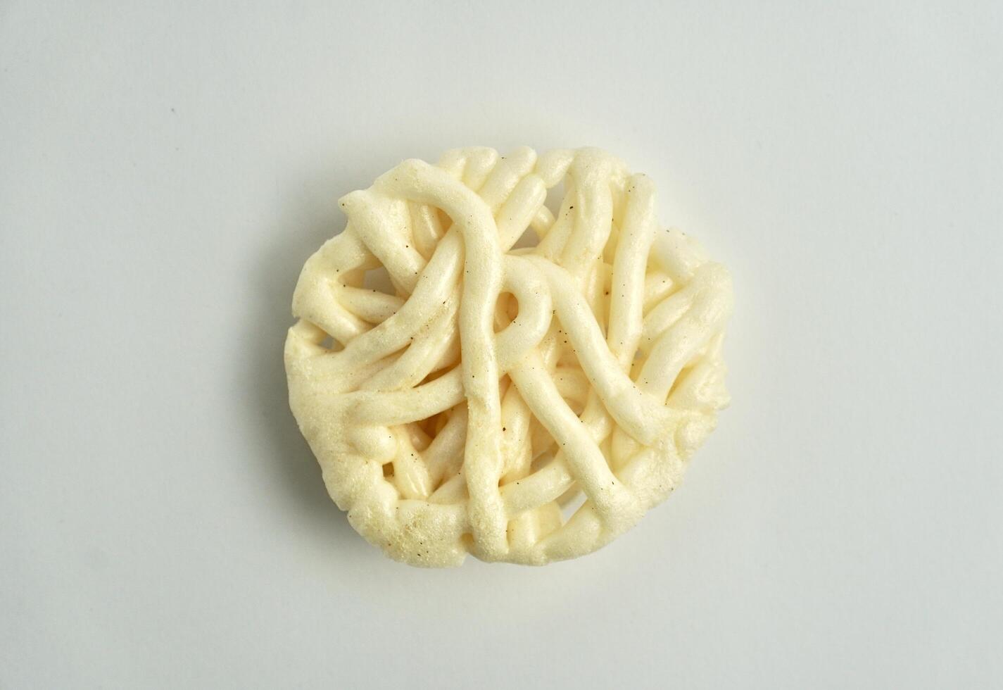One piece of white crackers snack. Kerupuk mawar warung putih food object photography isolated on white background. photo