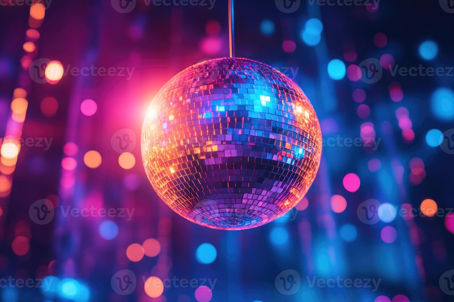 Shiny disco ball hanging from ceiling reflecting red and blue lights photo
