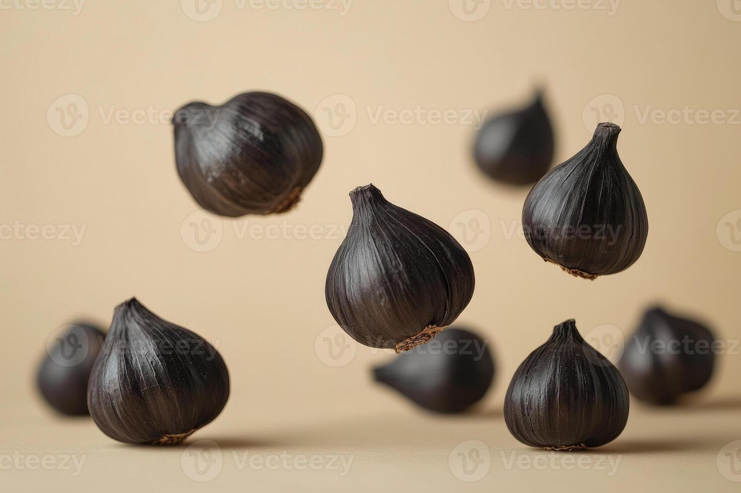 Black garlic bulbs floating on a minimal background photo