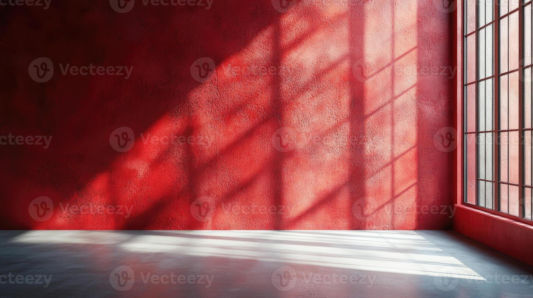 Sunlight casting geometric shadows on a red wall in an empty room photo