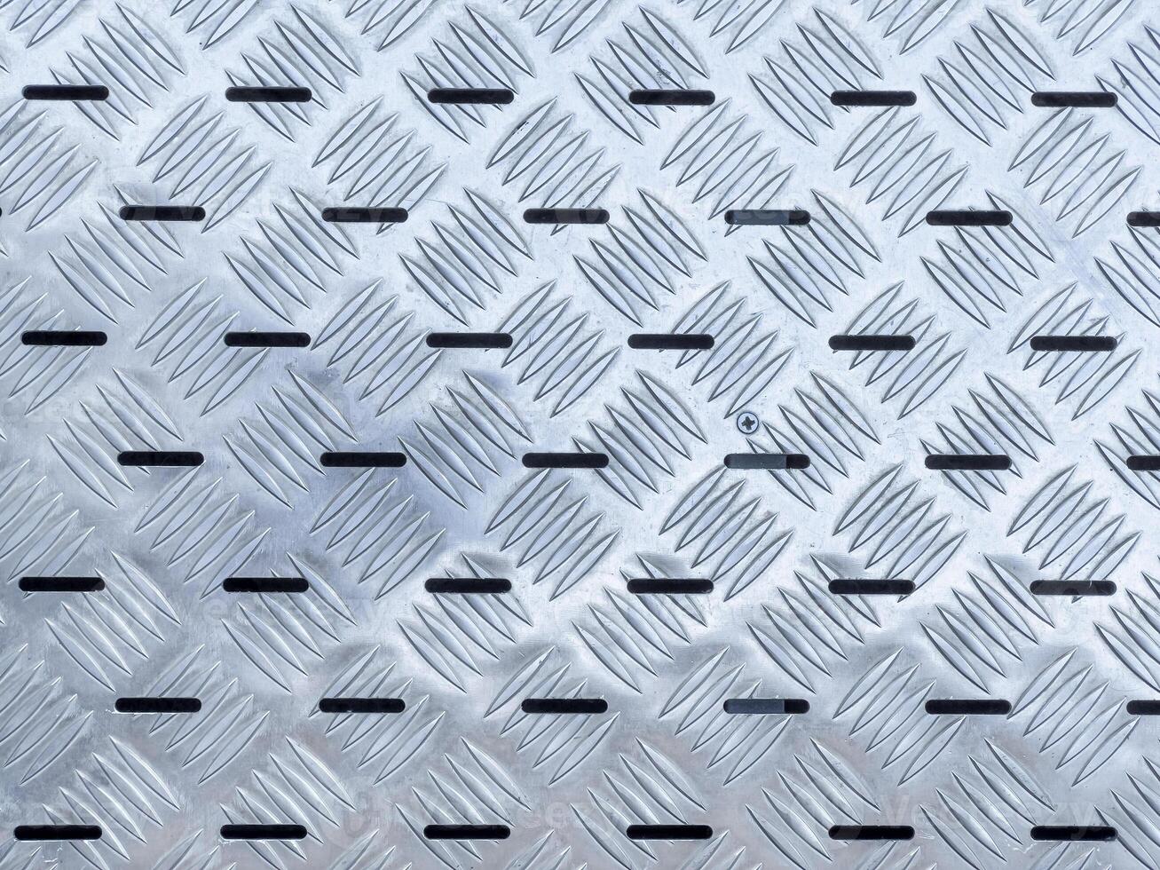Abstract background, texture of industrial building staircase made of non slip stainless steel metal plates photo
