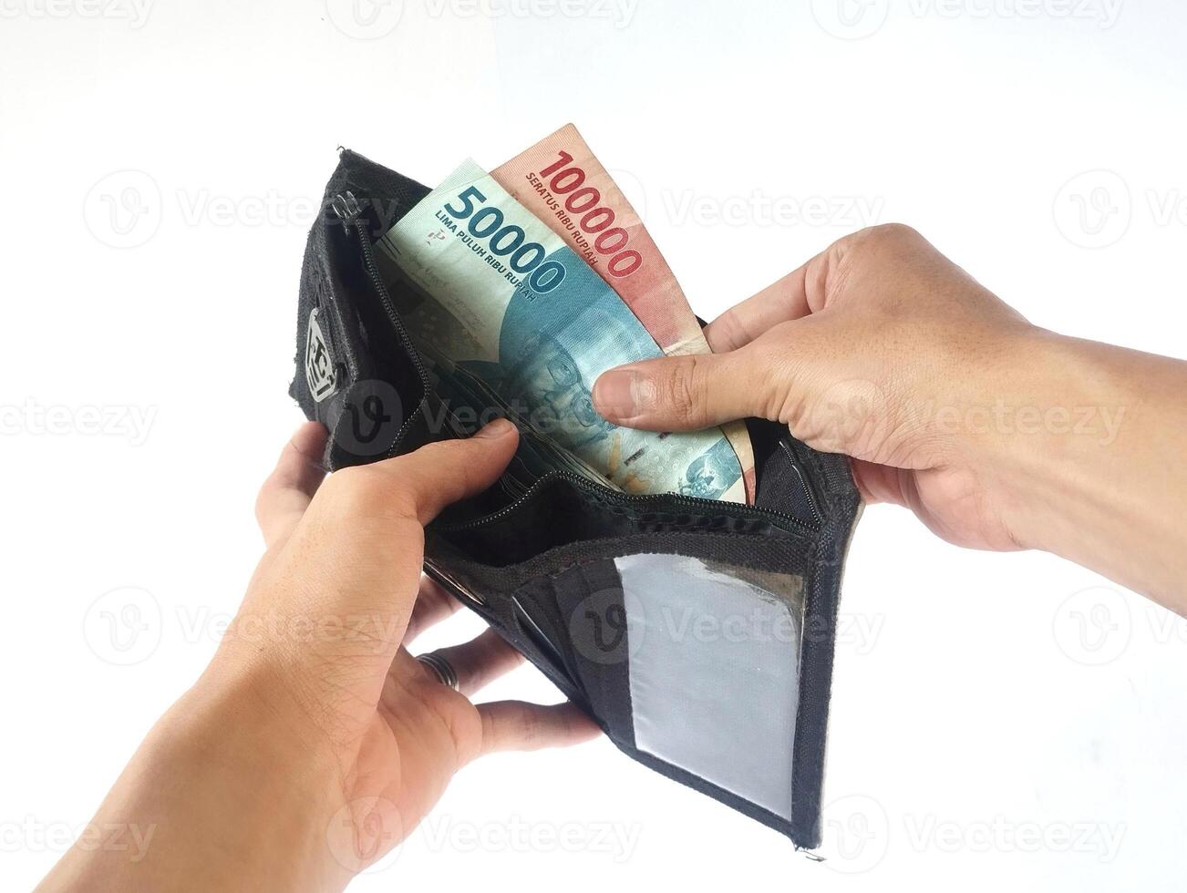 A man's hand takes and shows money from a wallet isolated on white background, rupiah is the currency of Indonesia photo