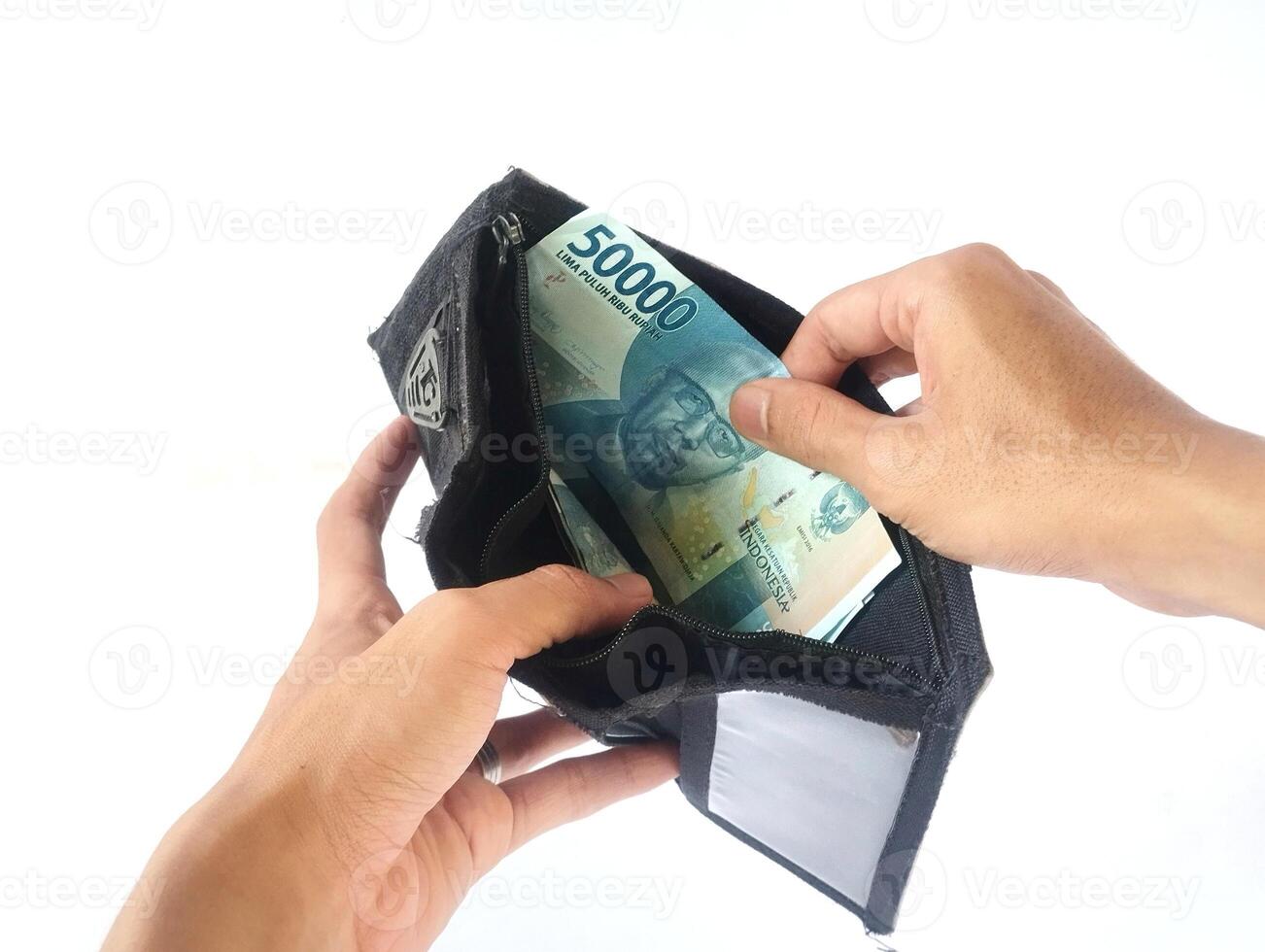 A man's hand takes and shows money from a wallet isolated on white background, rupiah is the currency of Indonesia photo