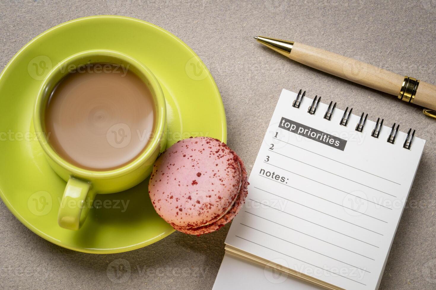 top priorities, notes in a small spiral notebook or calendar with a cup of coffee, time management concept photo