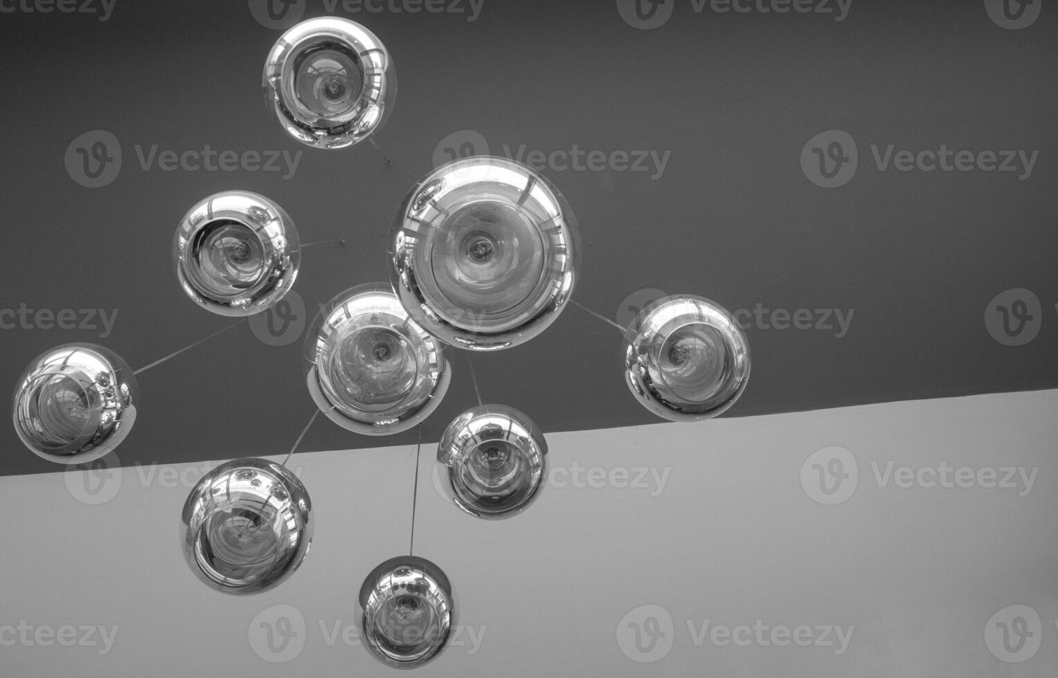Modern chandelier background, round lamps over ceiling pattern. Black and white photo background