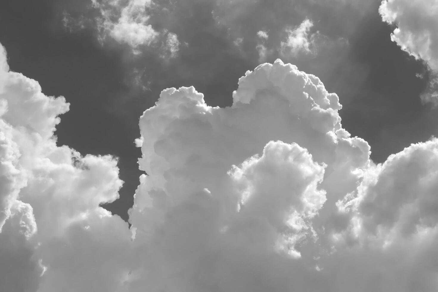 White clouds in blue sky. Black and white monochrome grayscale photo background.
