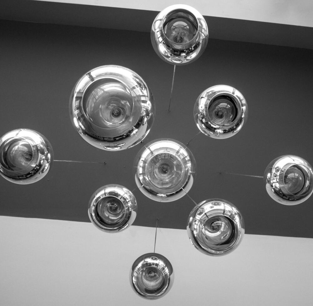 Modern chandelier background, round lamps over ceiling pattern. Black and white photo background