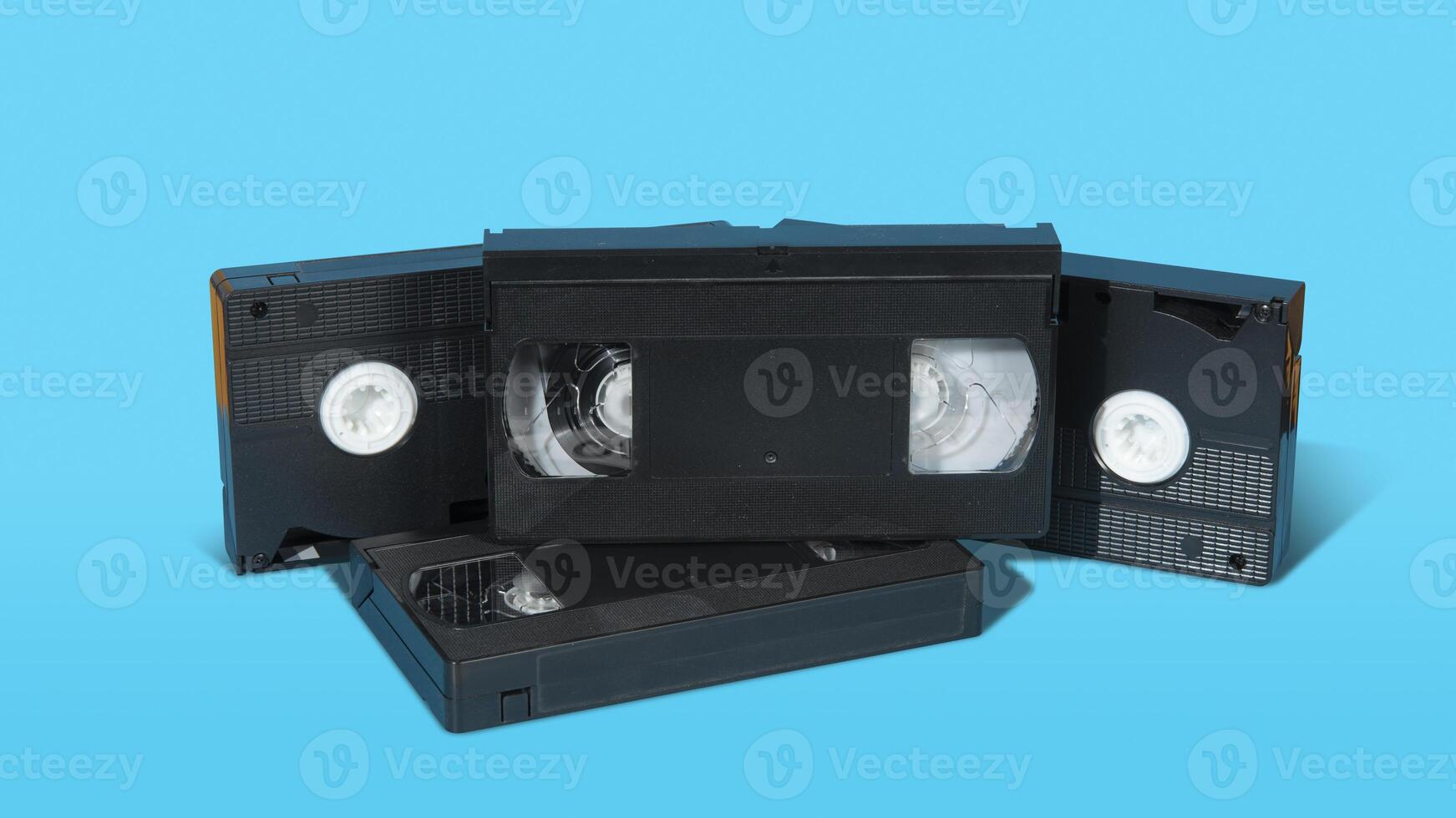 old black plastic VHS cassette with on a blue surface against blue background photo