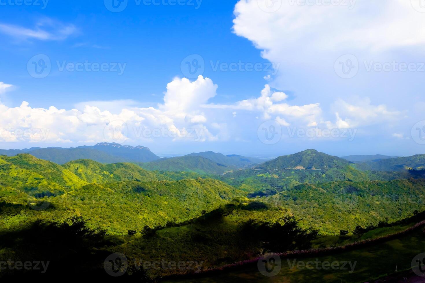 Big cloud full of sky, above the green mountain. photo
