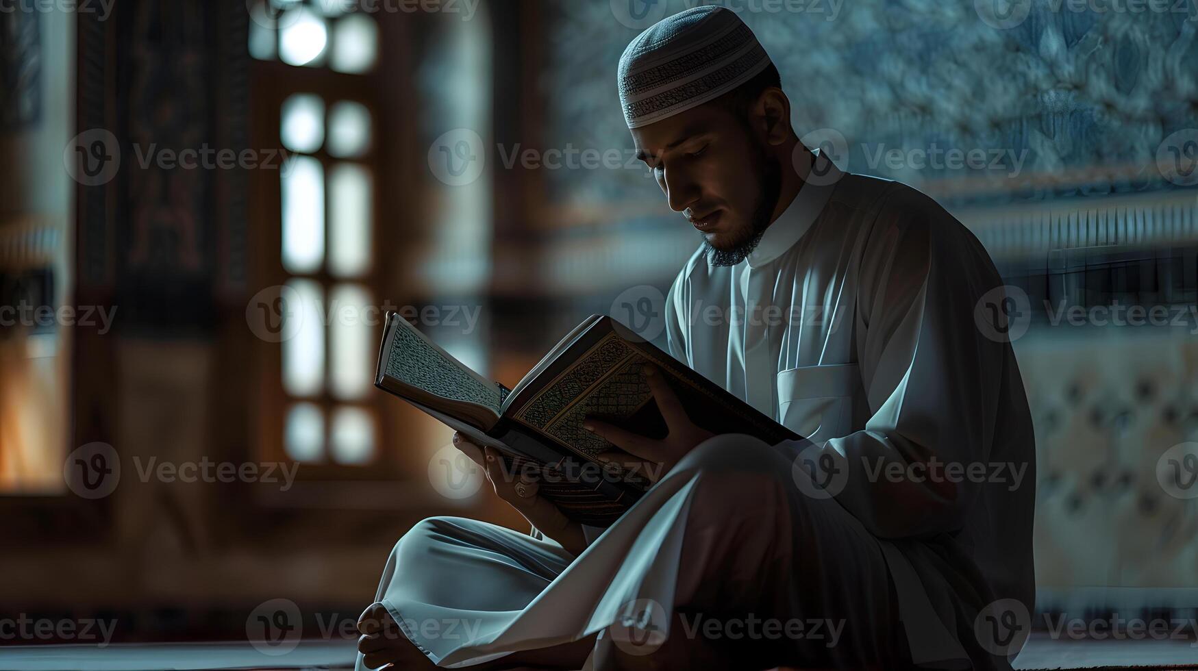 A Muslim man is reading the Quran in a peaceful setting with a dim and serene nighttime background. photo