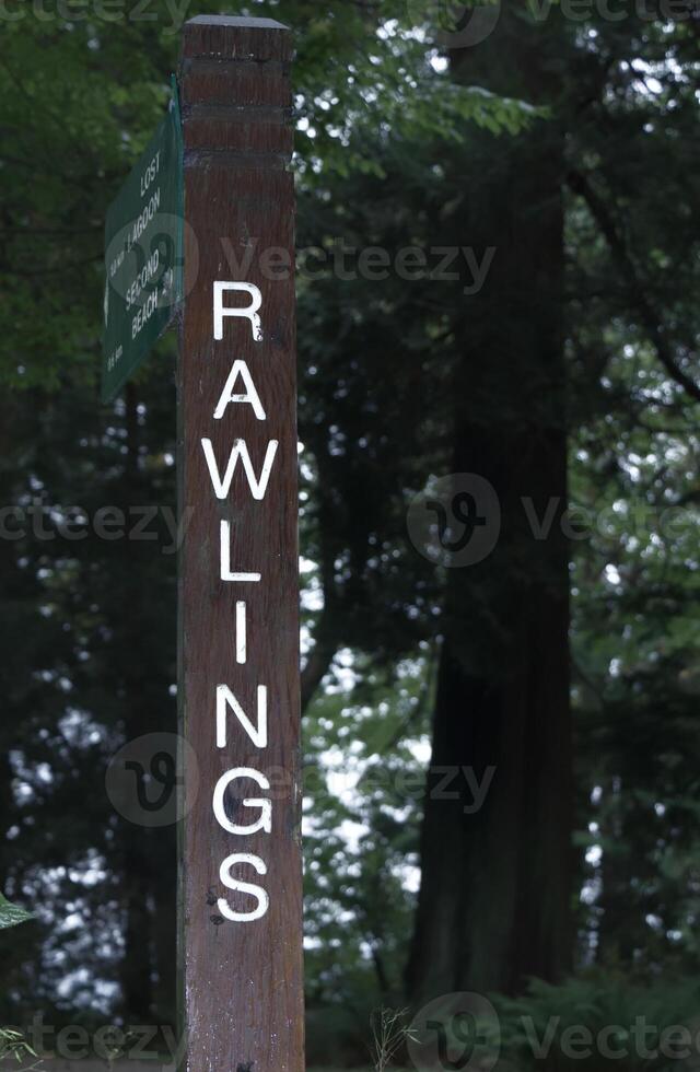 Vancouver, Canada - September 19,2019 Rawlings trail wooden sign in Stanley Park surrounded by deep Forest photo