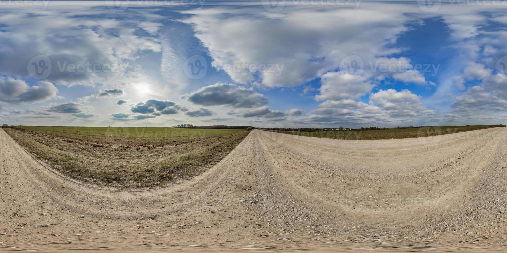 hdri 360 panorama on gravel road among fields in spring evening with awesome clouds in equirectangular full seamless spherical projection, for VR AR virtual reality content or sky replacement photo