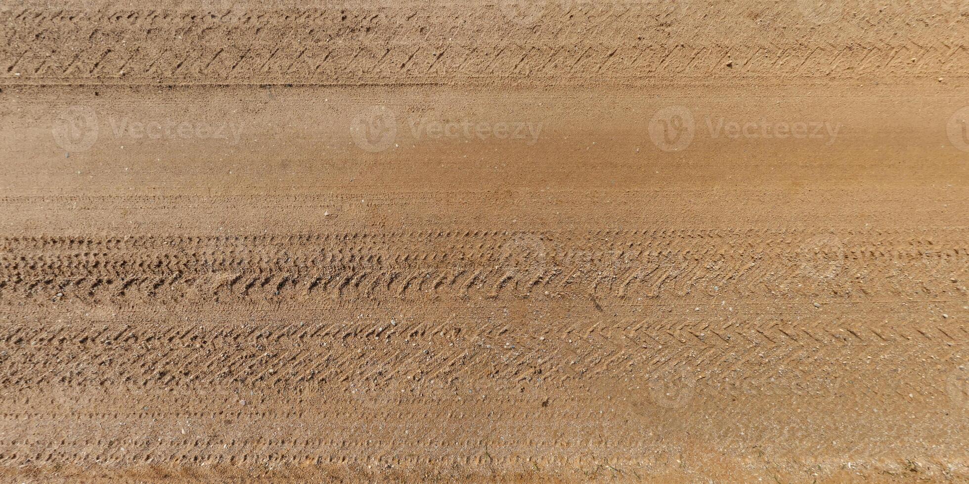 view from above on texture of dry muddy road with tractor tire tracks in countryside photo