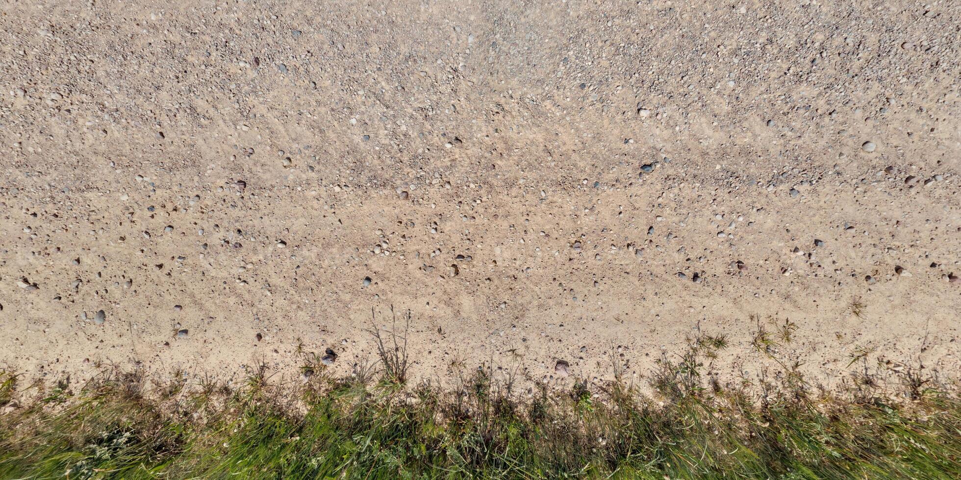 view from above on texture of dry muddy road with tractor tire tracks in countryside photo