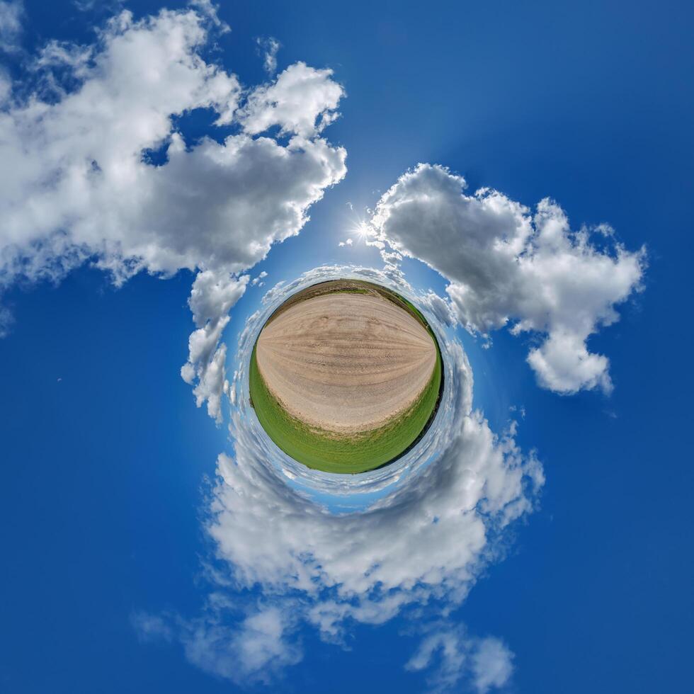simple little tiny planet without buildings in blue sky with beautiful clouds. Transformation of spherical panorama 360 degrees. Spherical abstract aerial view. Curvature of space. photo