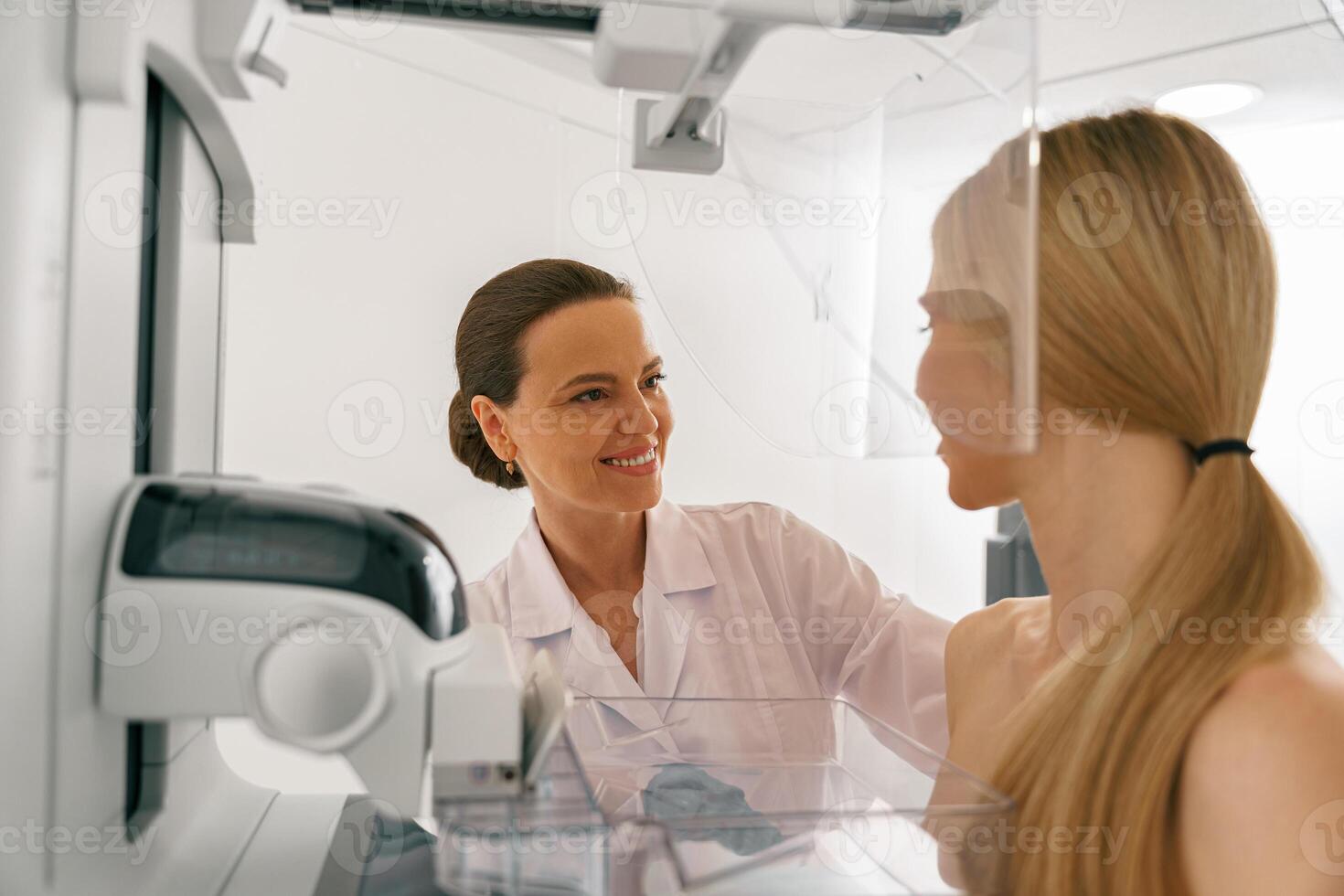 Close up of female radiologist doing mammogram x ray for young woman to check for breast cancer photo