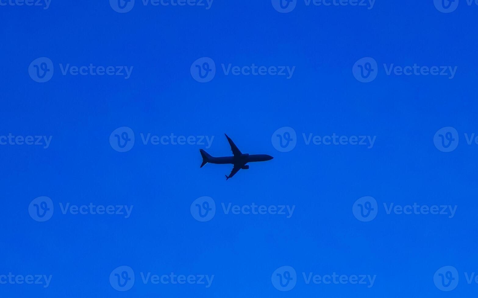 Passenger airplane flies in blue sky with clouds in Mexico. photo