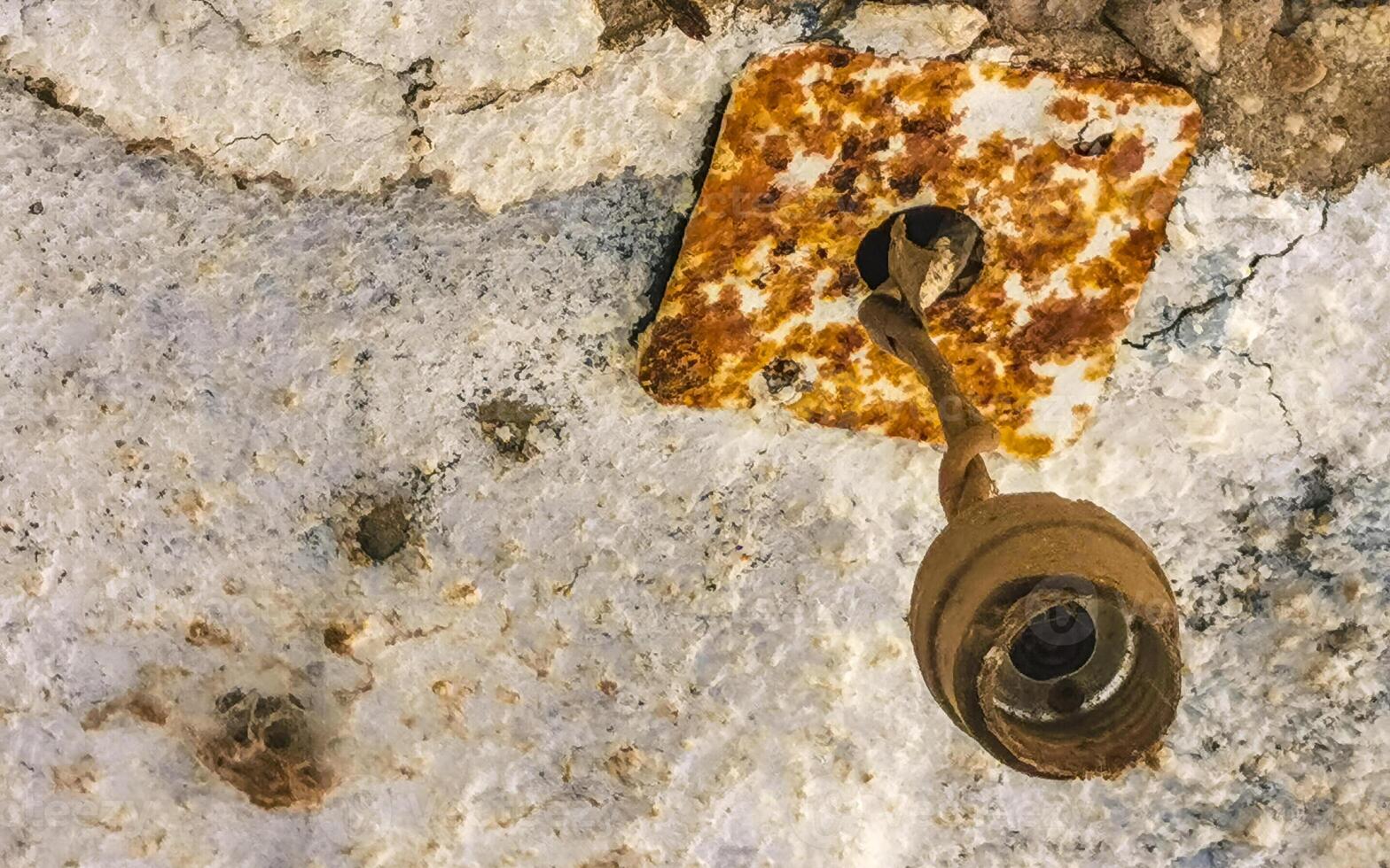 Old rusted light bracket on the wall in Mexico. photo