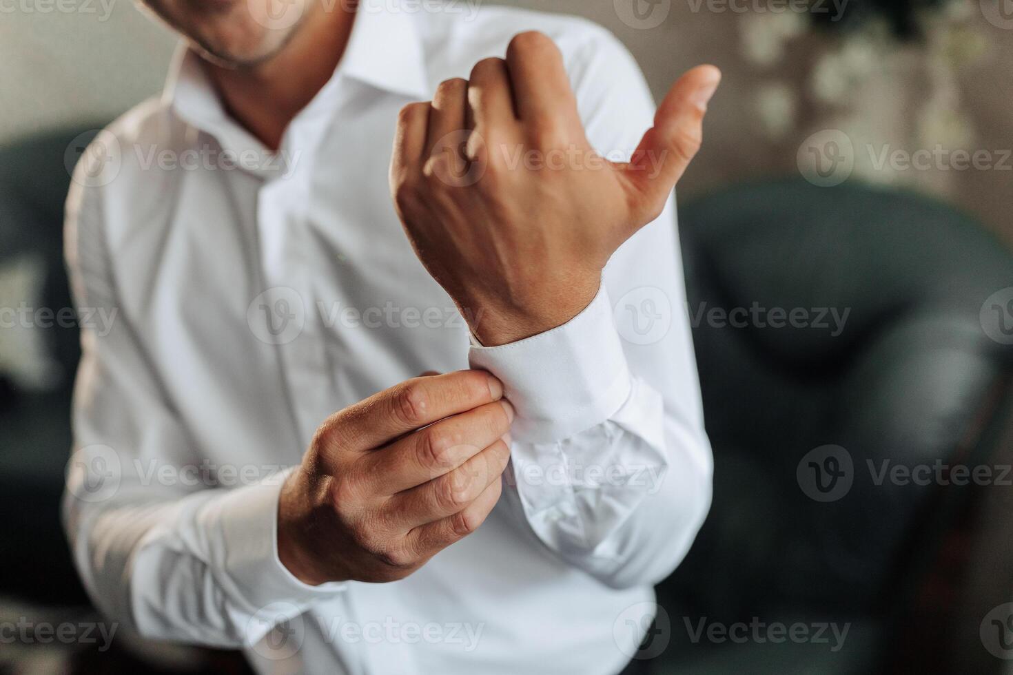 A man is getting dressed and adjusting his shirt. Concept of formality and attention to detail photo
