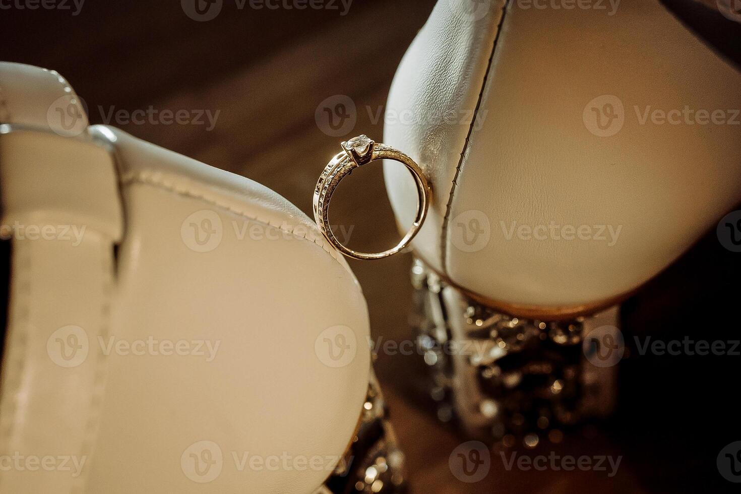 A ring is stuck in the toe of a white shoe. The ring is gold and has a diamond in the center photo