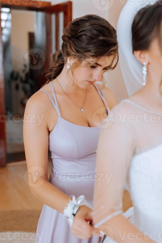 A woman in a purple dress is getting ready for a wedding. She is wearing a necklace and a white wristband photo