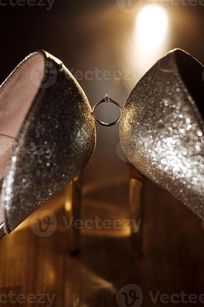 A pair of shoes with a ring on the left shoe photo