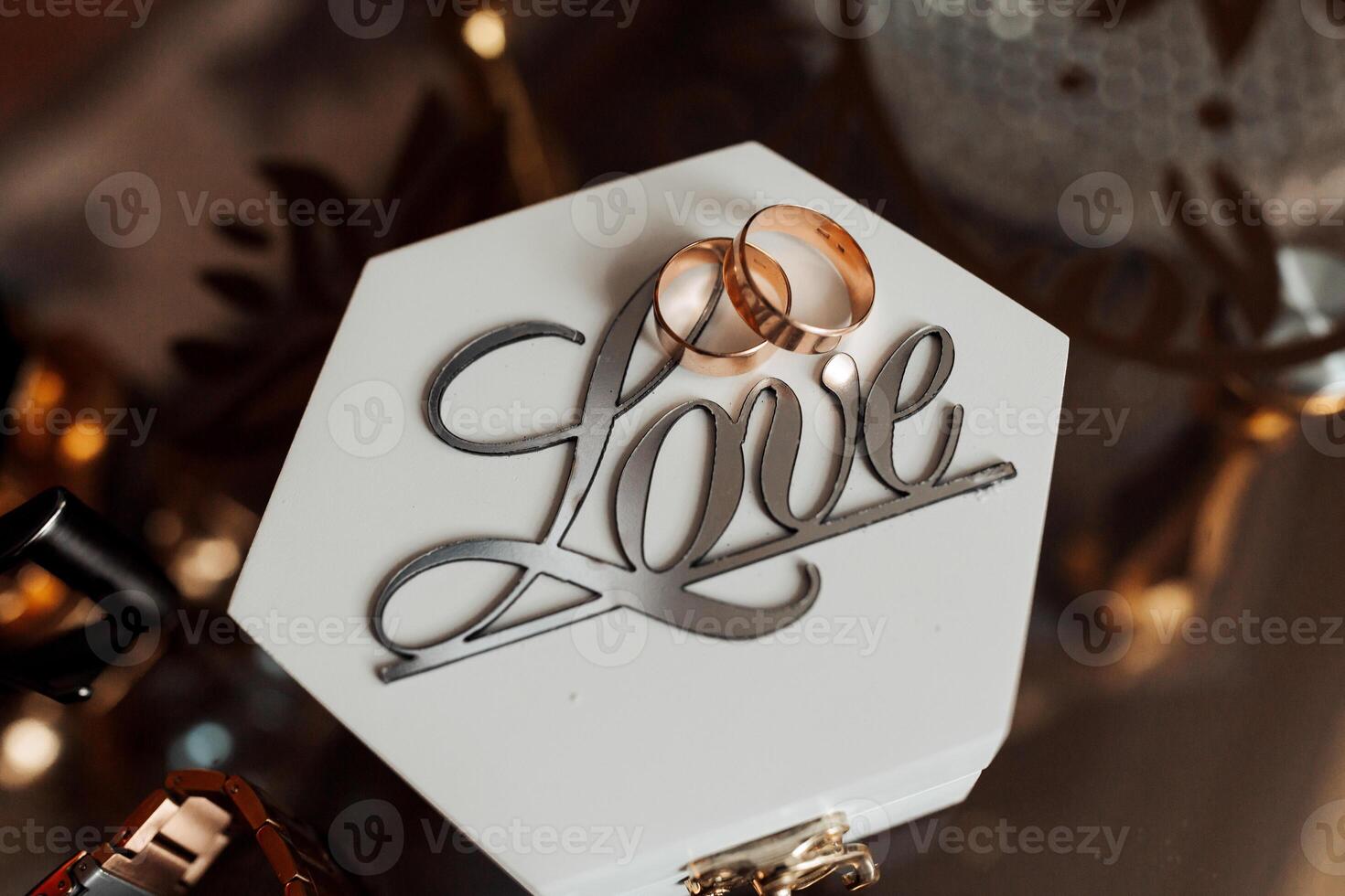A white box with a heart on it and two rings on top of it. The box is labeled Love photo