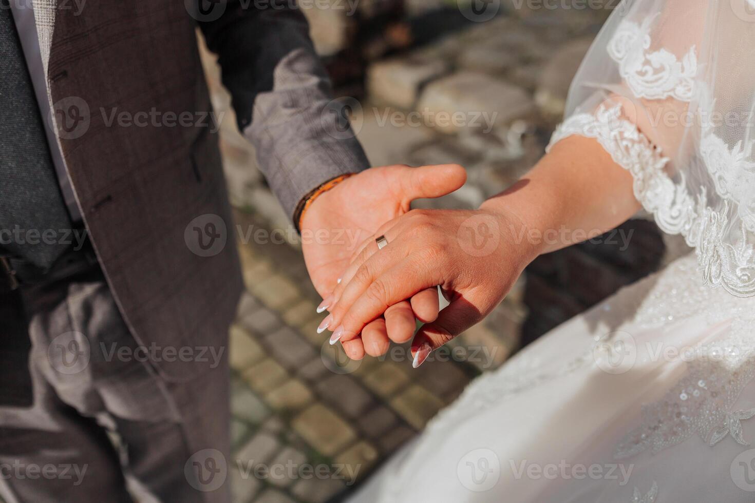 A man and woman are holding hands, with the man wearing a wedding ring. Concept of love and commitment between the couple photo