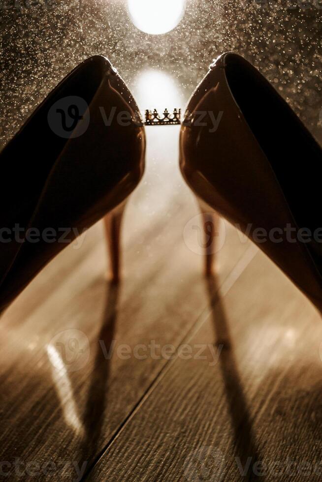 Two pairs of shoes with a crown on one of them. The crown is on the right shoe photo