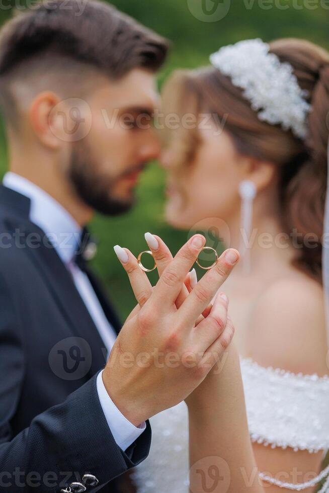 A man and woman are holding rings in their hands, possibly getting married. The man is wearing a suit and tie, while the woman is wearing a wedding dress. Concept of love and commitment photo