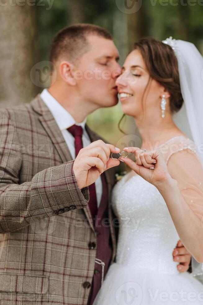 A man and woman are kissing and holding a key in their hands. The man is wearing a suit and tie, and the woman is wearing a wedding dress. Concept of love and commitment between the couple photo